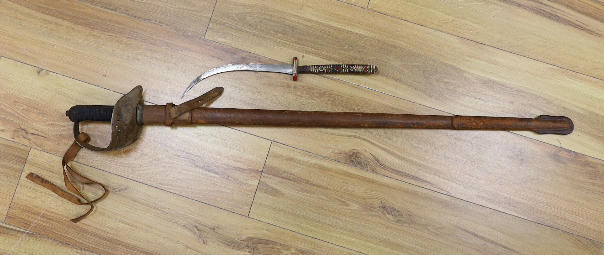 A George V military dress sword in brown leather covered scabbard, 102cm long, and a Middle Eastern dagger with carved and painted handle